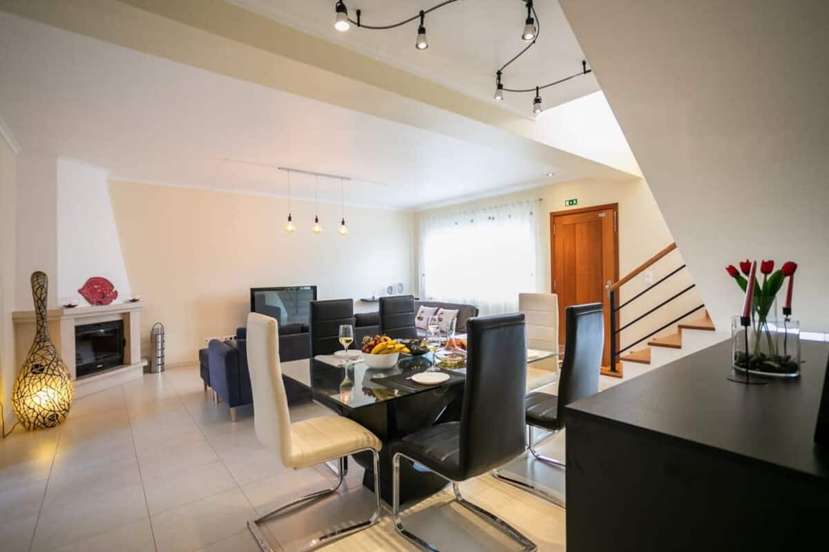 Open-plan dining and living area with a staircase and fireplace