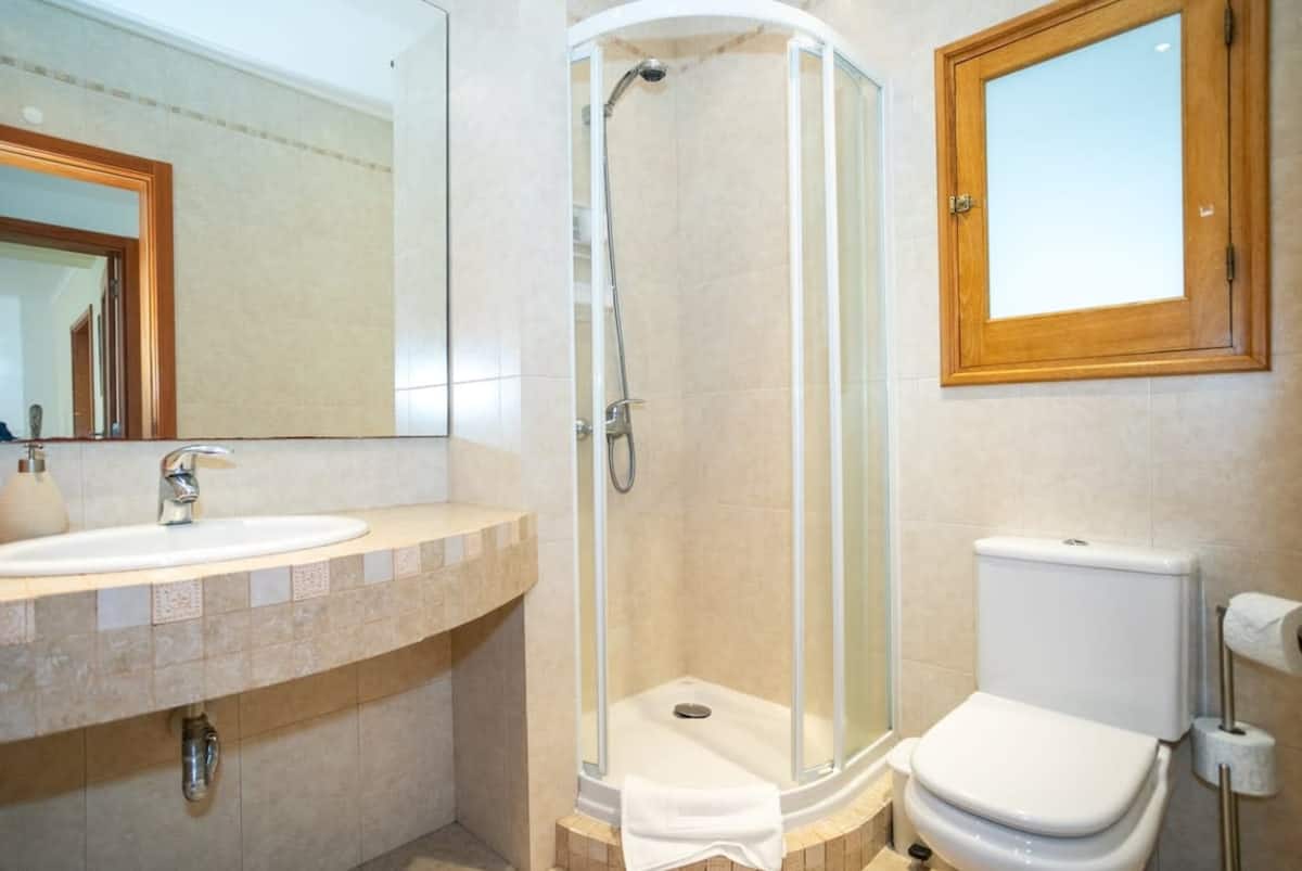 Bathroom with a corner shower, sink and toilet