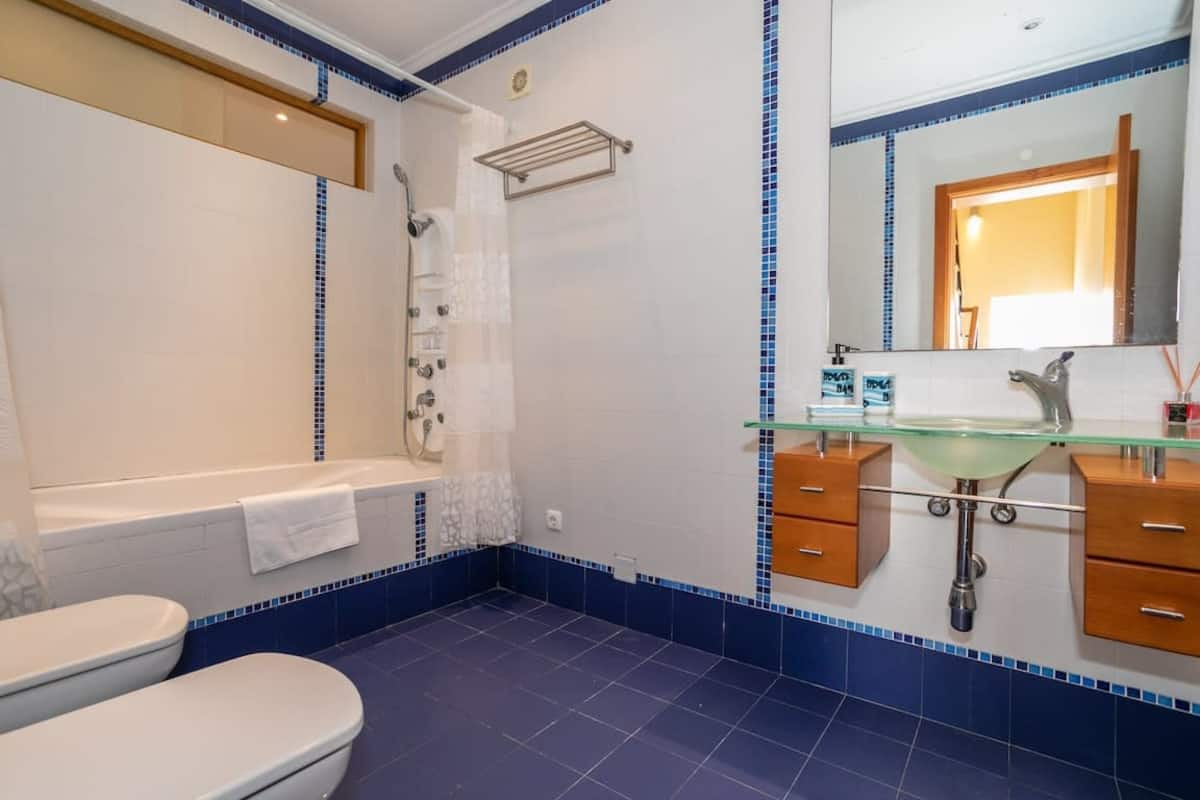 Blue-and-white bathroom with a bathtub, shower and vanity
