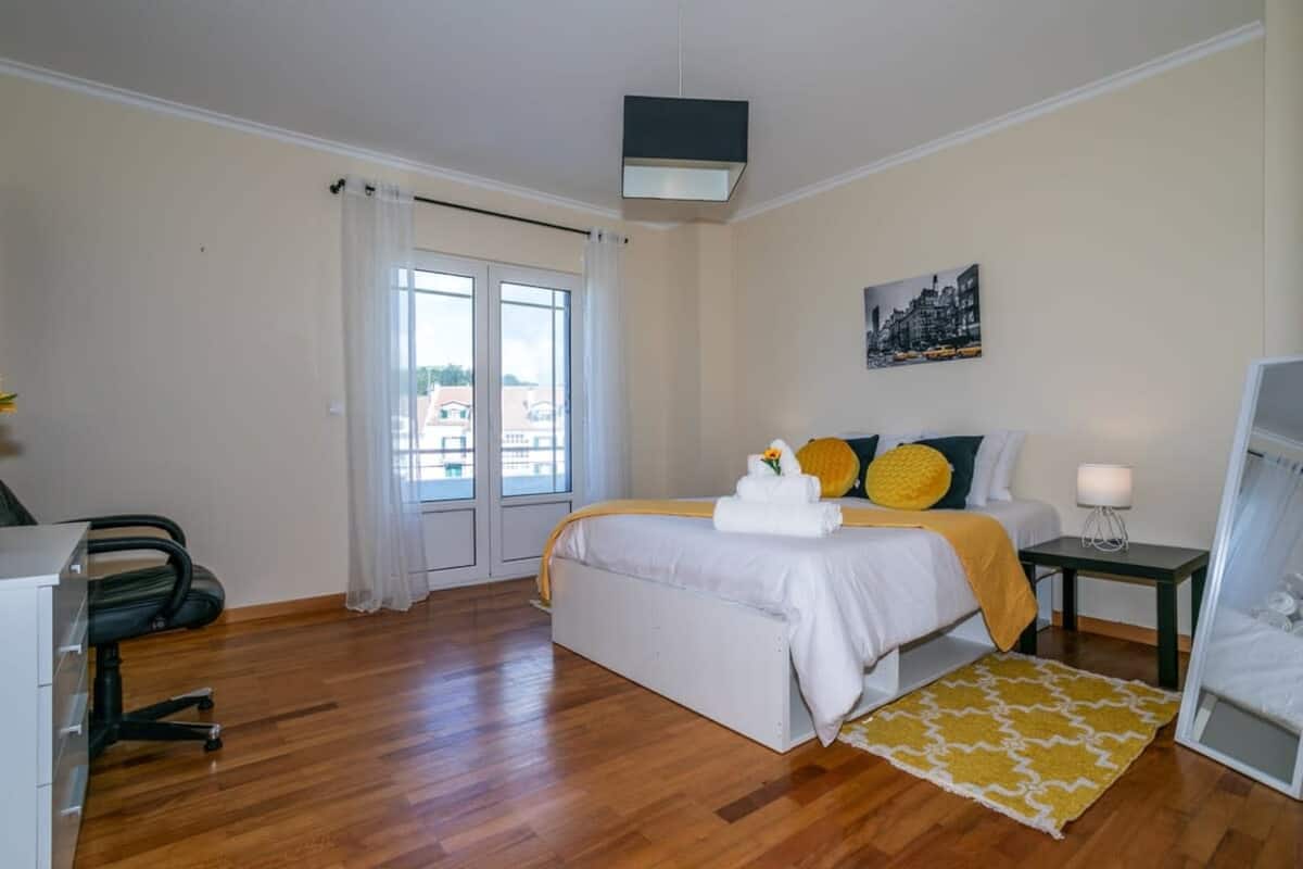 Double bedroom with yellow accents and balcony doors