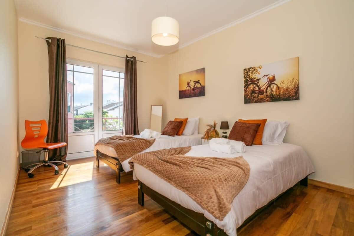 Bright bedroom with two single beds and balcony doors