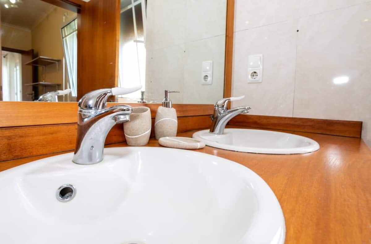 Bathroom vanity with two sinks, a wood counter and a large mirror